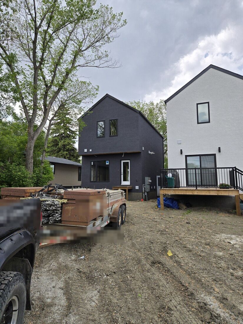 The same narrow house finished in dark stucco