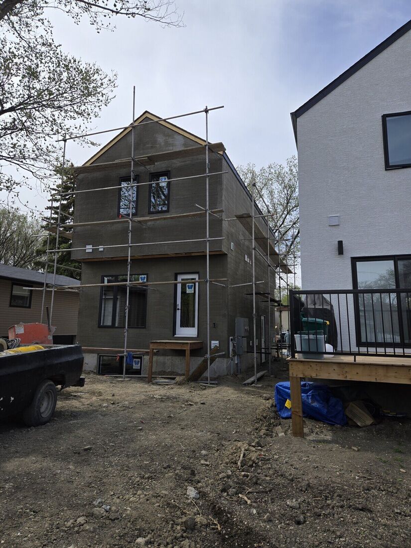 Narrow house in base coat with scaffolding