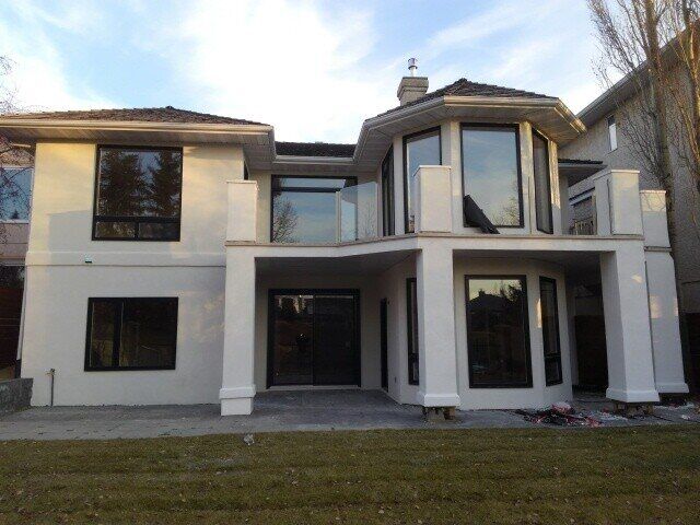 The same house with a smooth white stucco finish and a glass railing