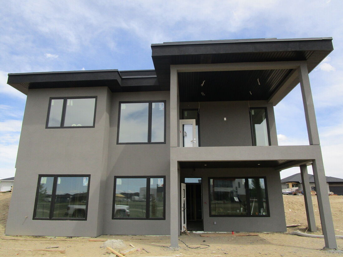 The same house finished in grey stucco with a covered deck