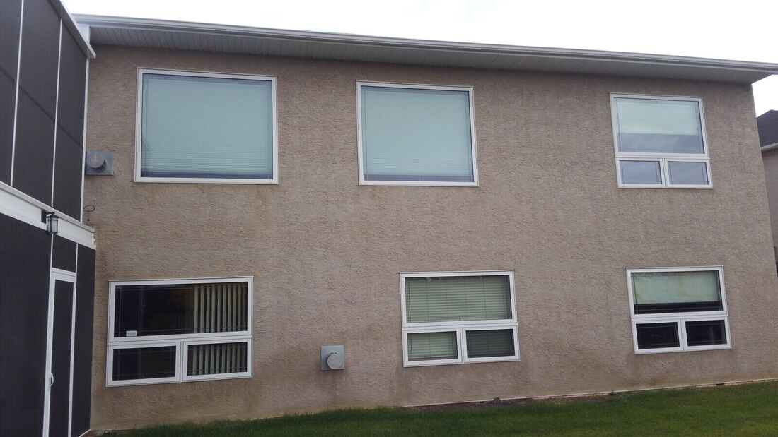 Back of a house with weathered brown stucco