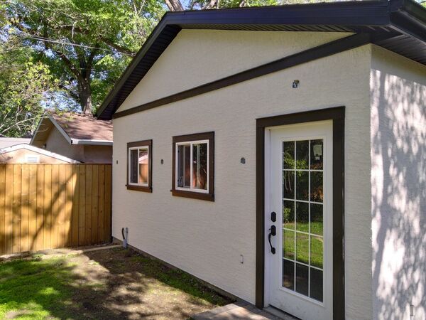 Small white stucco garage with dark trim