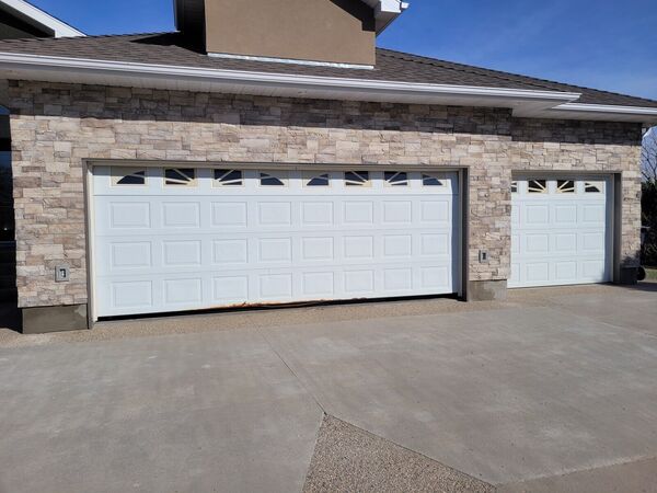 Stone-clad garage front with white doors