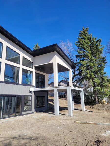 Rear of a modern house with stucco columns and a covered patio