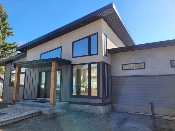 Modern house entry with cedar posts and dark vertical siding