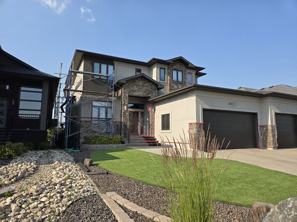 Large stucco and stone house with a three-car garage