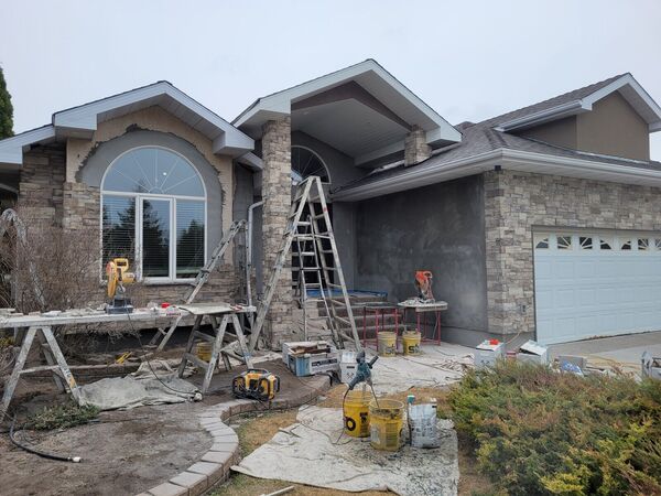 Stucco and stone work underway on a bungalow front