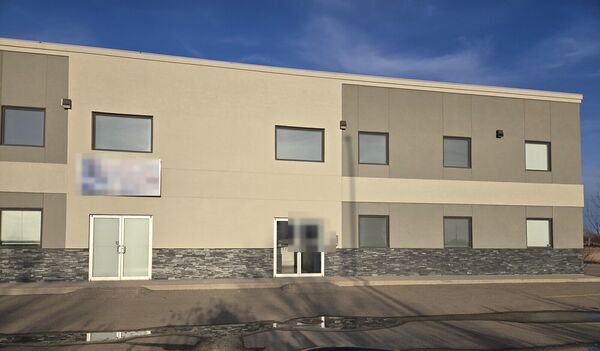 The building finished in tan stucco with a stone base