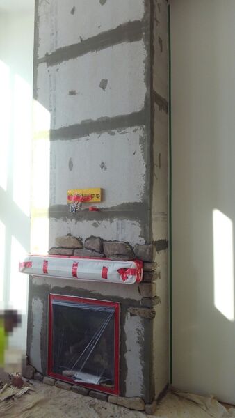 Tall fireplace chimney wall in cement board with stone work just starting