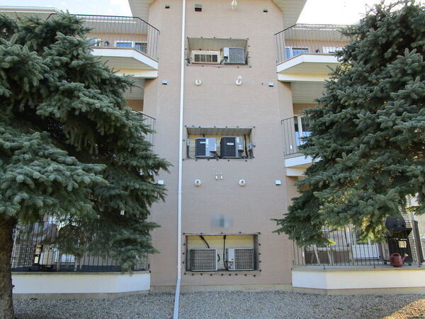 The same apartment tower re-clad in tan stucco
