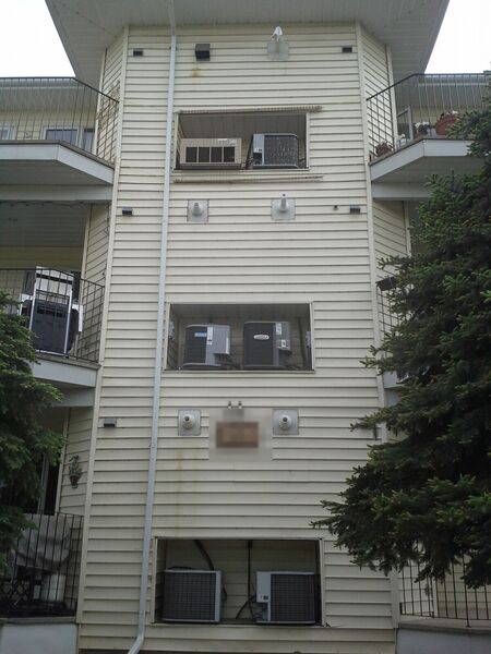 Apartment building tower with old vinyl siding