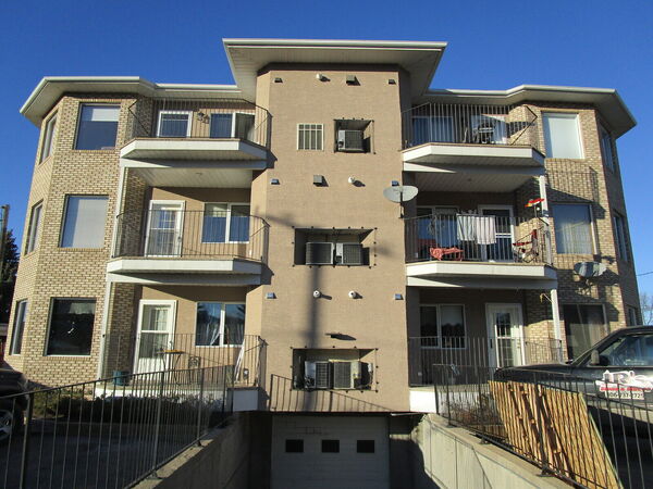 The same apartment building re-finished in tan stucco beside brick