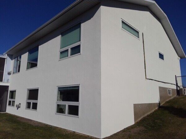 The same side of the house in clean white stucco